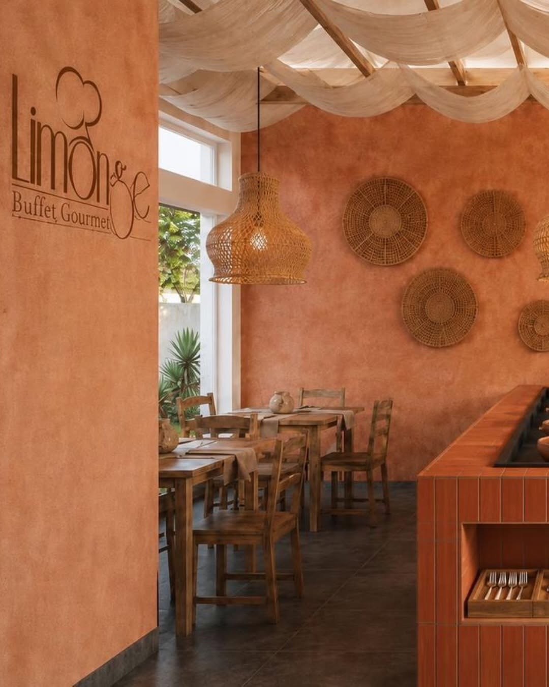 Salão da Limonge com paredes de barro e luminárias de vime